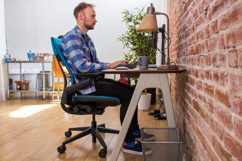 A visual showing ideal ergonomic workstation with lumbar support, foot positioning, and screen height.